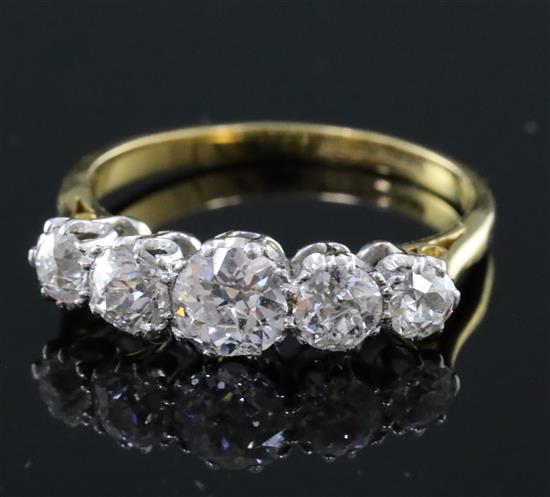 An 18ct gold and platinum, graduated five stone diamond half hoop ring, size M.